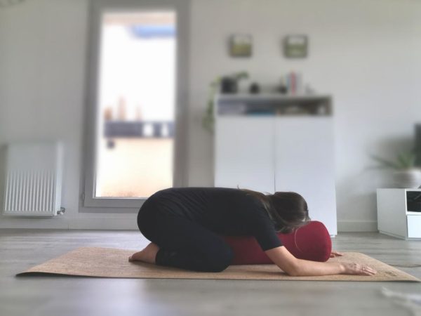 Posture de l'enfant sur boslter de yoga
